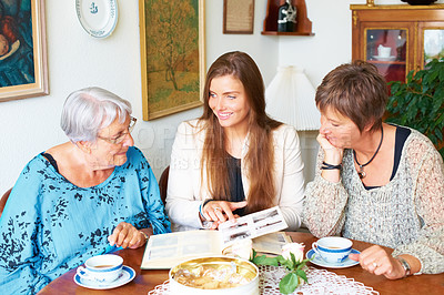 Buy stock photo Family photo, memory and lunch with mother and grandmother with a smile together. Tea, elderly woman and house dining room table with women and happy from album to remember in retirement in a home