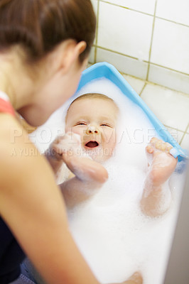 Buy stock photo Baby, mother or play in bathtub for shower, cleaning and hygiene with foam or bubbles for bonding. Child, woman or washing infant in bathroom of home for parenting, development and love with water