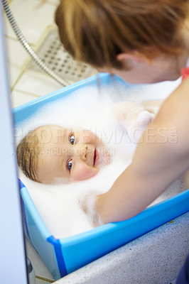 Buy stock photo Baby, mother or smile in bathtub for shower, cleaning and hygiene with foam or bubbles for enjoyment. Child, woman or washing infant in bathroom of home for parenting, development and love with water