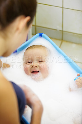 Buy stock photo Baby, mother or happy in bathtub for shower, cleaning and hygiene with foam or bubbles for enjoyment. Child, woman or washing infant in bathroom of home for parenting, development and love with water