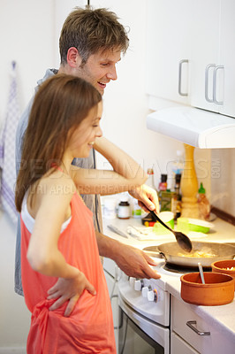 Buy stock photo Young, couple and cooking of dinner in kitchen, together and bonding for relationship. Man, woman and talking by stove by preparation of yummy, delicious or meal for health, nutrition or diet in home