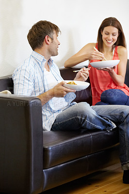 Buy stock photo Couple, dinner and living room couch with conversation an discussion with food and chopsticks. Lounge, happy and marriage with lunch and eating with a smile and communication on a sofa with love