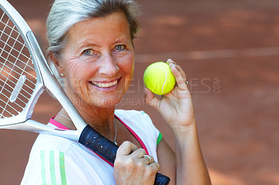 Buy stock photo Attractive senior woman in sportswear holding a tennis racquet and ball