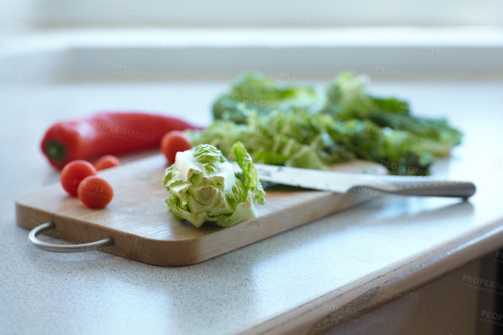 Buy stock photo Chopping board, vegetables and knife on table in kitchen cooking organic food. Cutting wood, blade and plants on counter, lettuce and tomatoes, pepper and nutrition for healthy diet or salad in home