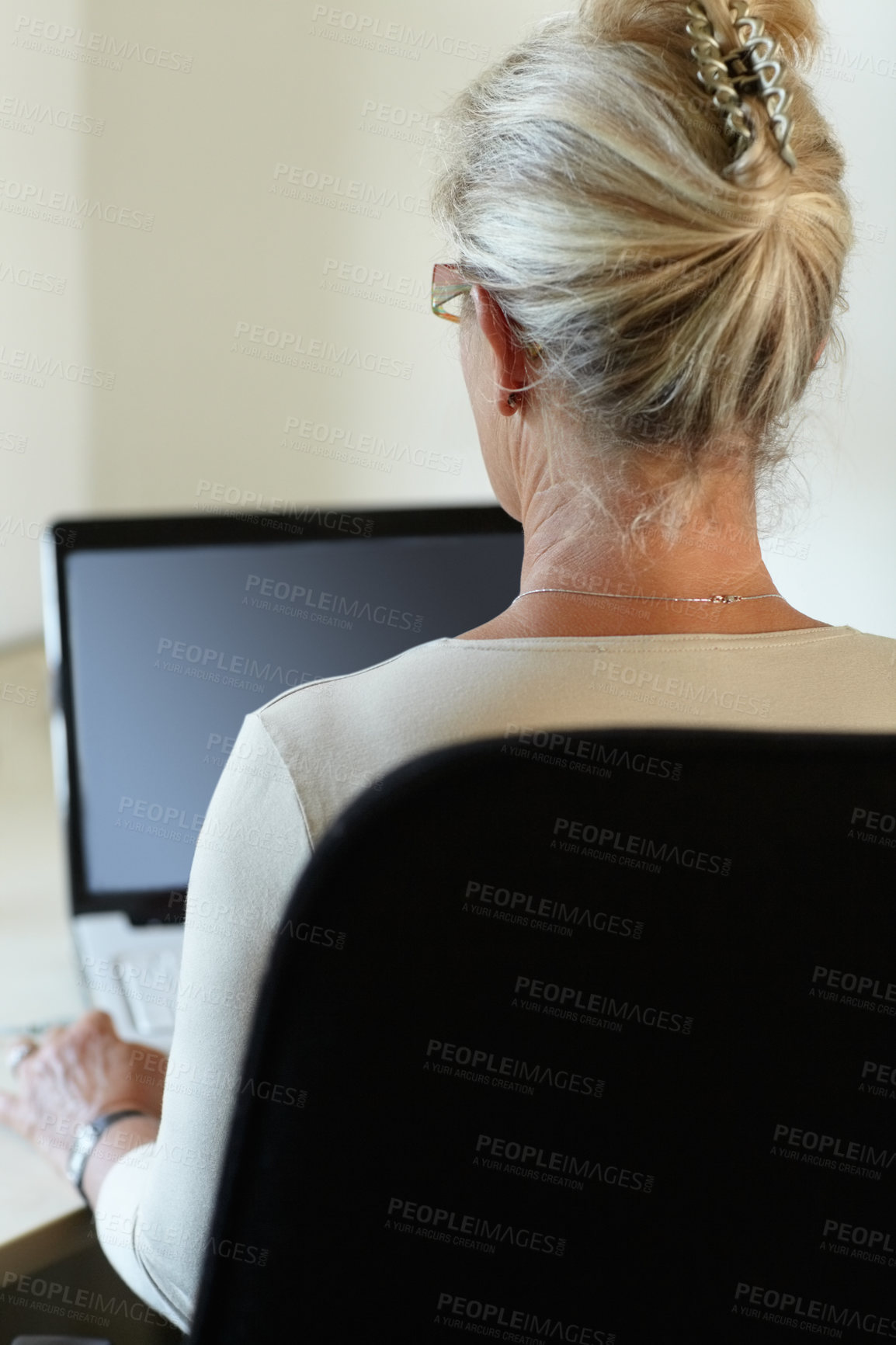 Buy stock photo Rear-view of a woman working on her laptop