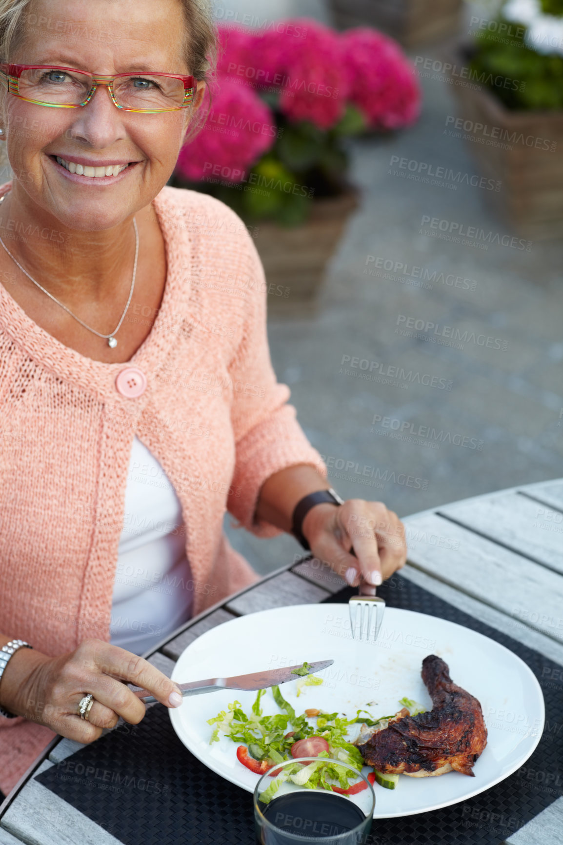 Buy stock photo A senior woman enjoying a delicious meal outdoors in the evening