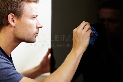 Buy stock photo Young man cleaning the screen of his smart TV