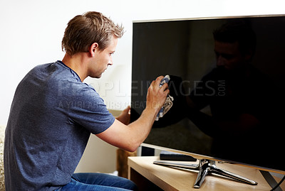 Buy stock photo Young man cleaning the screen of his smart TV
