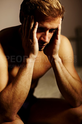 Buy stock photo Stressed young guy with his head in his hands
