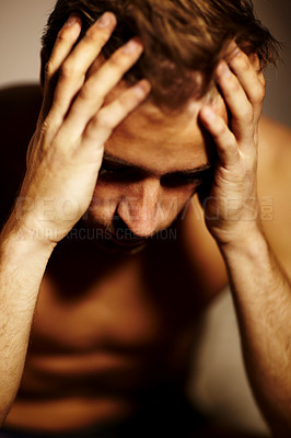 Buy stock photo Stressed young guy with his head in his hands