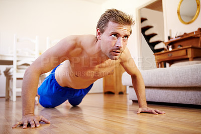 Buy stock photo Handsome young guy doing push-ups at home