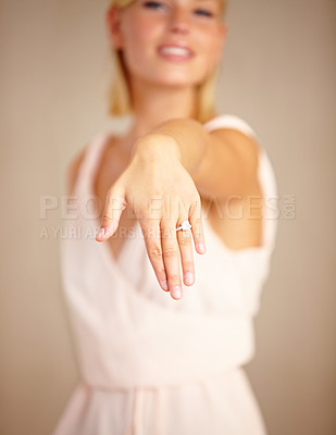 Buy stock photo Cropped shot of a young woman displaying her engagement ring