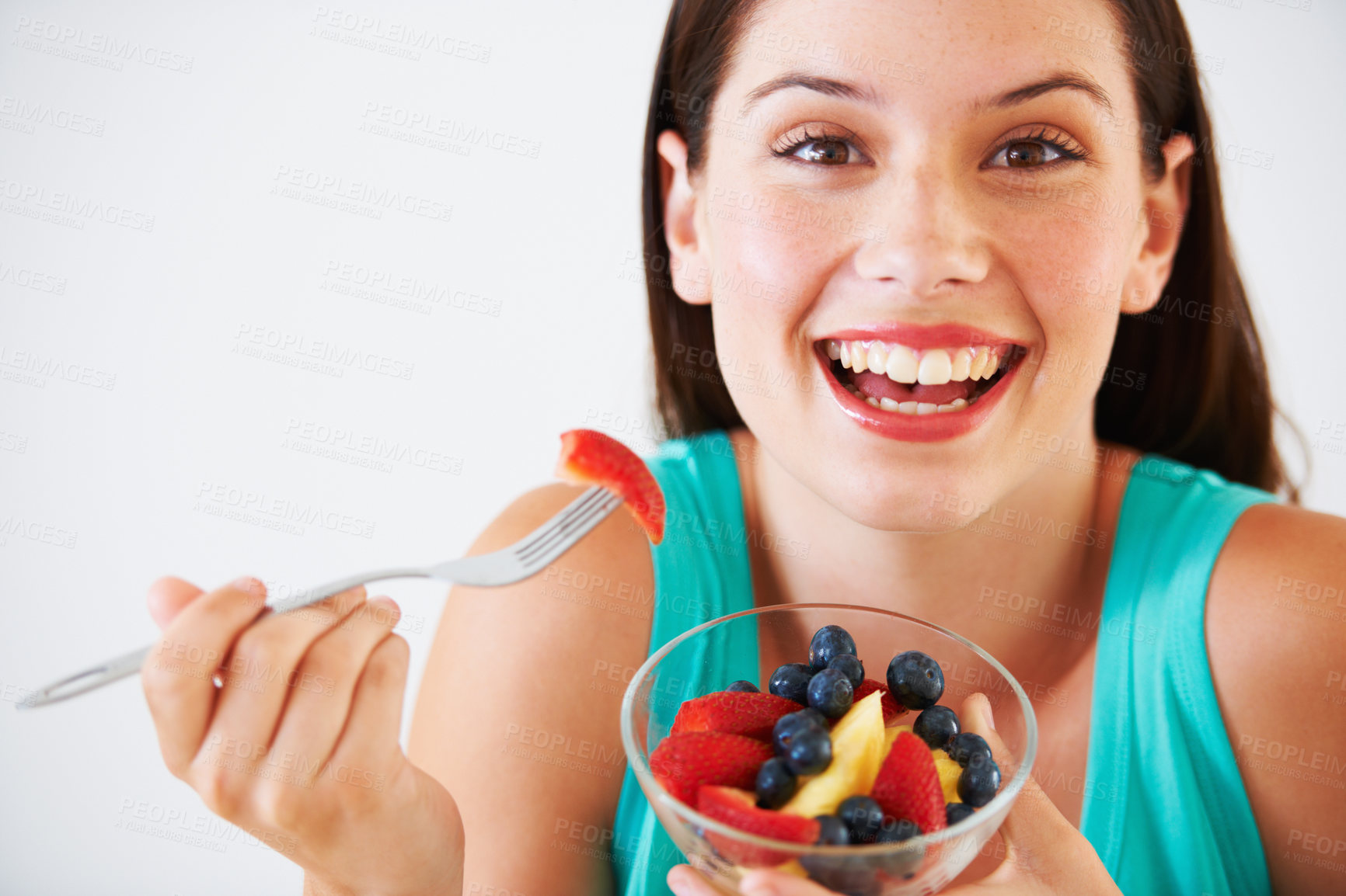 Buy stock photo Diet, fruit salad and portrait of happy woman in studio eating for nutrition, wellness and snack. Food, health and face of person with berries for vitamins, detox and lose weight on white background