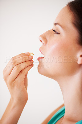 Buy stock photo Profile of an attractive young woman about to take a vitamin