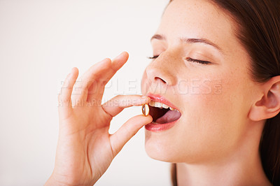 Buy stock photo Healthy, woman and eating a supplement, pill and tablet for nutrition, diet and vitamin c benefits. Happy, face and girl with pharmaceutical capsule with omega 3, magnesium and healthcare medicine