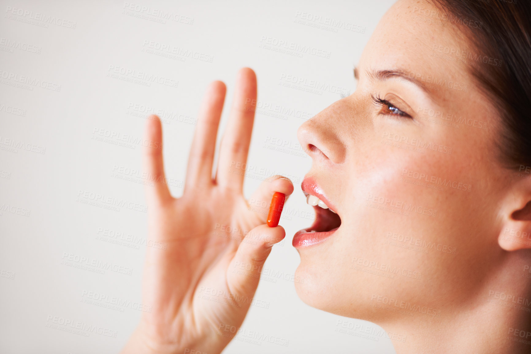 Buy stock photo Profile of a beautiful young woman about to take a tablet