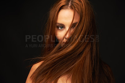 Buy stock photo Portrait of a beautiful redhead with her hair covering her face on a black background