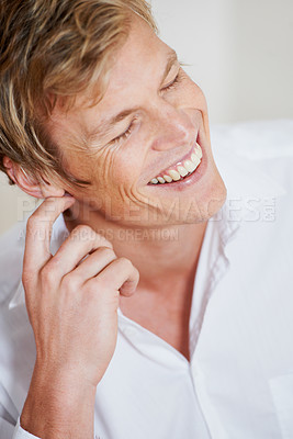 Buy stock photo Face, smile and laughing with a man closeup in a shirt for comedy, humor or enjoying a joke. Comic, happy or funny and a young model excited by a meme with his eyes closed for carefree laughter