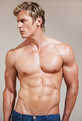 Buy stock photo Cropped shot of a muscular young man posing in studio
