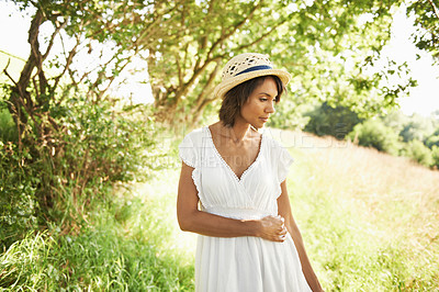 Buy stock photo Woman, field and spring with hat, sunshine and thinking on walk in green nature for memory, relax and adventure. Girl, outdoor and ideas by trees, grass and freedom on countryside holiday in summer