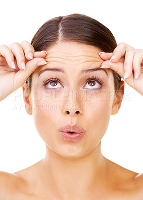 Buy stock photo Studio shot of a beautiful young woman pinching the skin on her forehead isolated on white