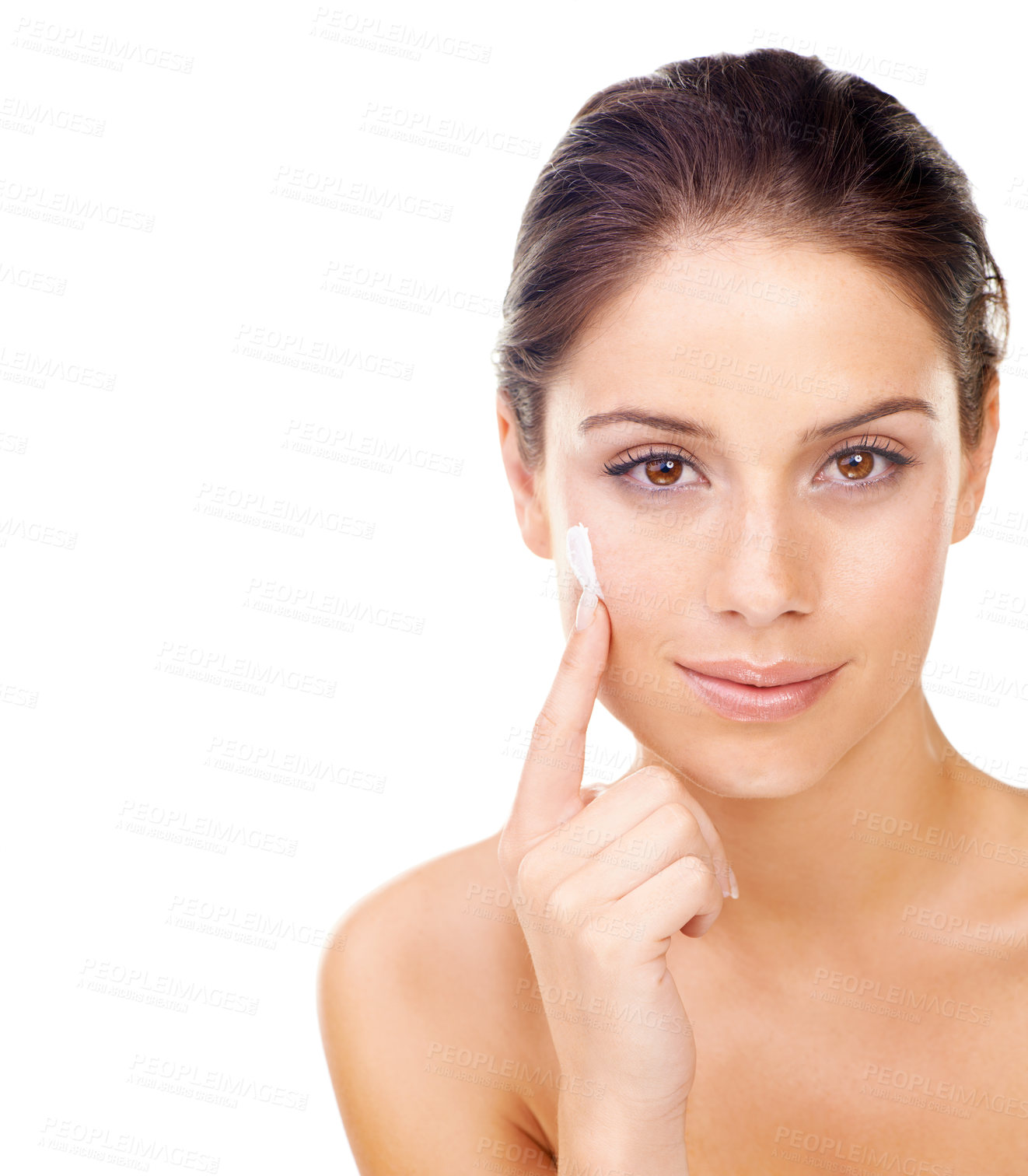 Buy stock photo Studio portrait of a beautiful young woman applying a skincare product to her face