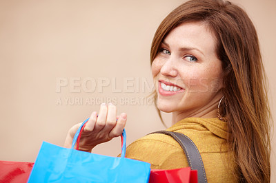 Buy stock photo Over the shoulder portrait of an attractive young woman holding shopping bags