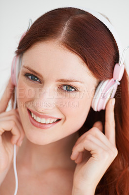 Buy stock photo Smile, headphones and portrait of woman in a studio listening to music, playlist or album. Happy, excited and young female model from Canada streaming a song or radio isolated by white background.