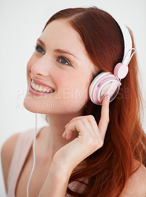 Buy stock photo Smile, headphones and young woman in a studio listening to music, playlist or album. Happy, excited and female model from Canada streaming a song, podcast or radio isolated by white background.