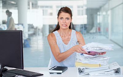 Buy stock photo Portrait, stress and pile of documents with a business woman in her office and looking worried about a deadline. Paper, report and backlog with a young female employee feeling overwhelmed at her desk