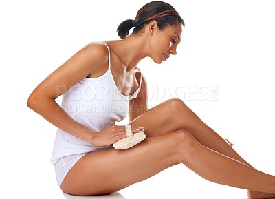 Buy stock photo Wellness, exfoliation and woman scrub her legs in a studio for a self care, clean and natural routine. Cosmetic, health and female model from Mexico doing a body care treatment by a white background.