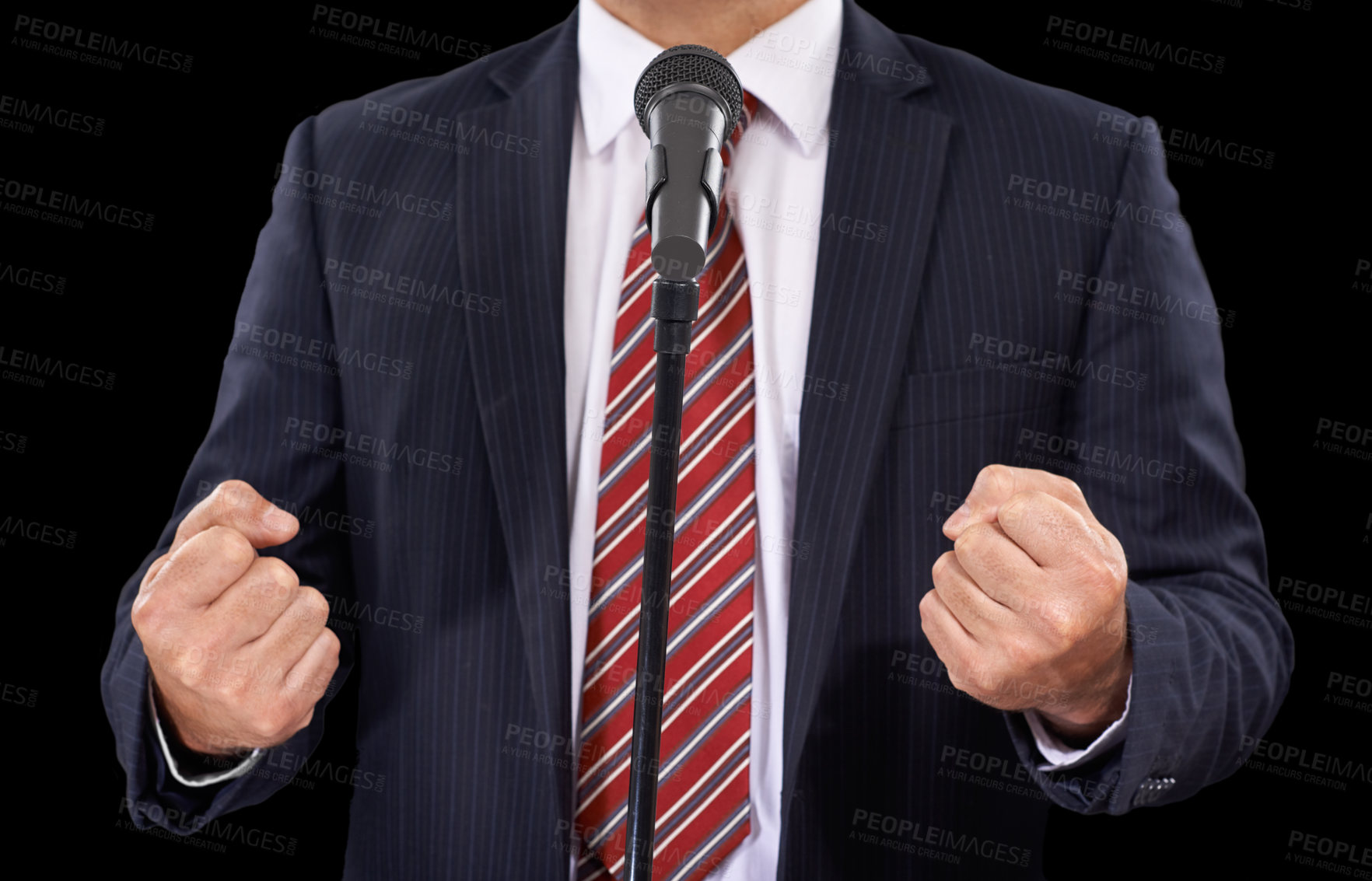 Buy stock photo Cropped view of a man in a suit speaking into a microphone with his hands in fists
