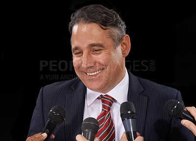 Buy stock photo Man, speech and politician at press conference to media for election, forum or broadcast to audience in studio on black background. Politics, government and happy public speaker talking at microphone