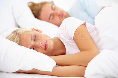 Buy stock photo A young couple sleeping in bed together