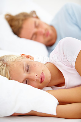 Buy stock photo Love, sleep and a couple in bed in the morning to relax in their home together for holiday or vacation. Face, dreaming or eyes closed with a young woman and man in the bedroom of their apartment