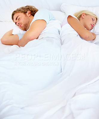 Buy stock photo A young couple sleeping back to back in bed