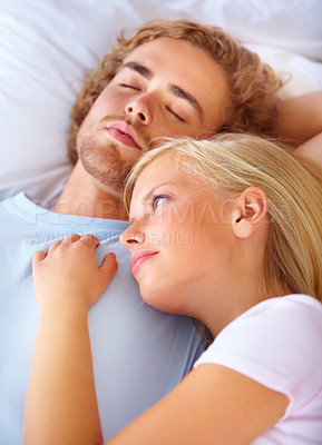 Buy stock photo Face, thinking and love with a couple in bed together to relax in the morning or to wake up in their home. Peace, marriage and young woman lying on the chest of her boyfriend in the apartment bedroom