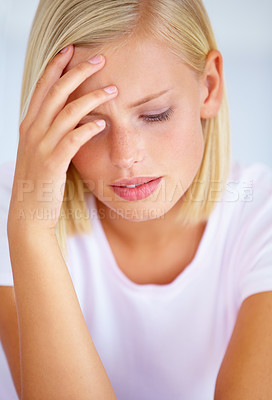 Buy stock photo A worried young woman sitting in her bed
