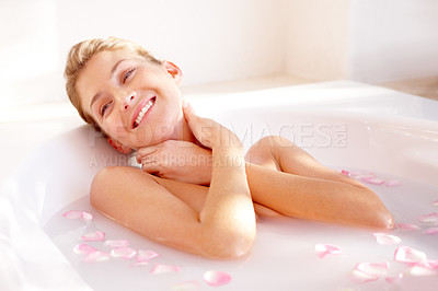 Buy stock photo A gorgeous young woman lying in a luxurious bath of rose petals