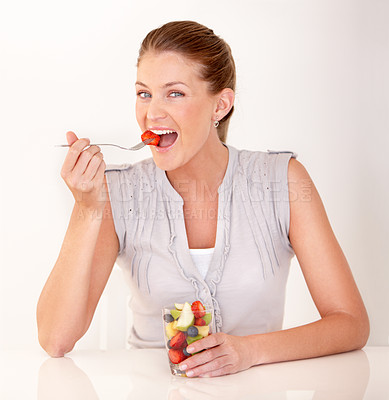 Buy stock photo Woman, eating portrait and fruit salad in a studio with happiness from healthy breakfast and food. Smile, young female person and diet nutrition of a model with organic fruits for wellness and health