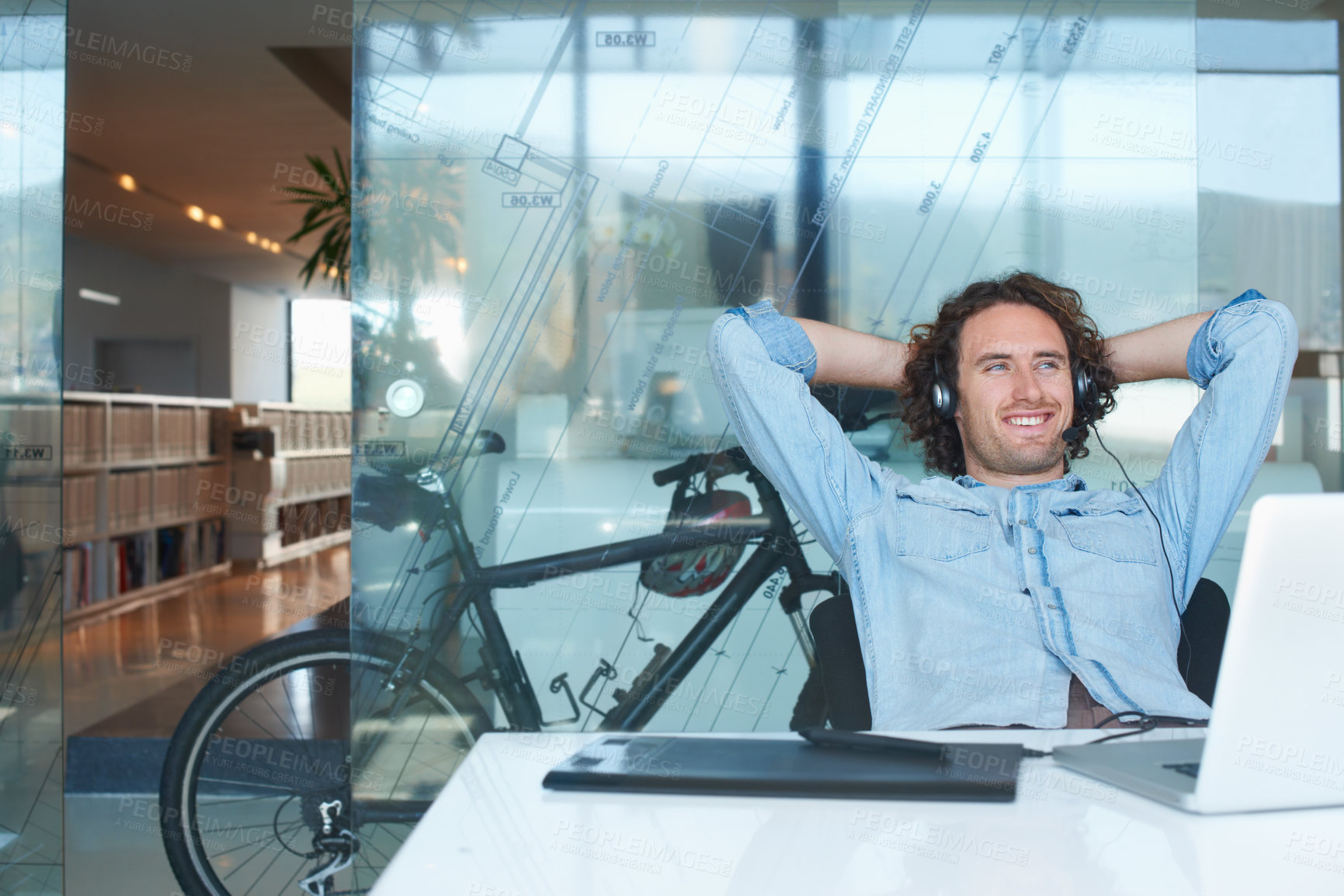 Buy stock photo Cropped shot of a young businessman looking relaxed while sitting in the office