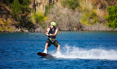 Buy stock photo Man, wakeboarding and water with helmet, sport and fitness for speed on vacation in summer sunshine. Person, athlete and ski with rope for safety on lake, sea or river for training, exercise or waves