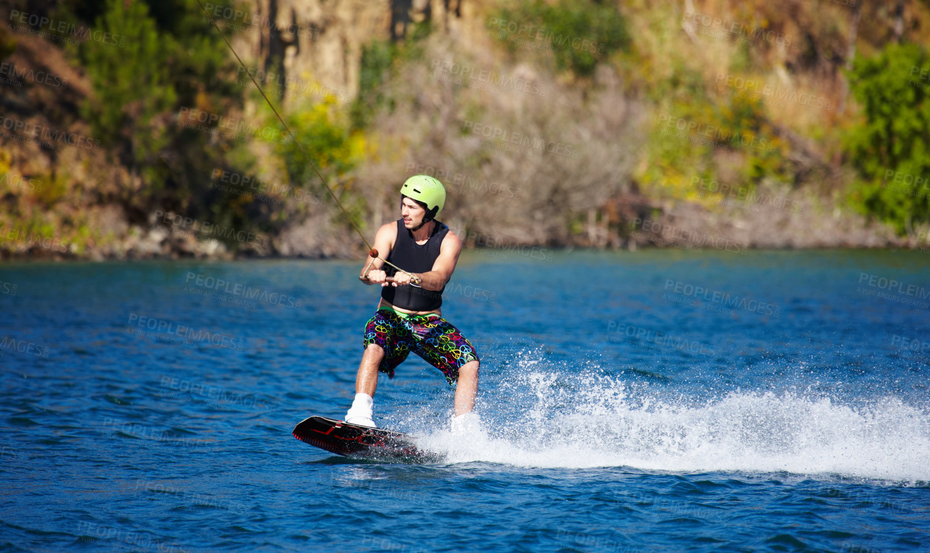 Buy stock photo Man, wakeboarding and water with helmet, sport and fitness for speed on vacation in summer sunshine. Person, athlete and ski with rope for safety on lake, sea or river for training, exercise or waves