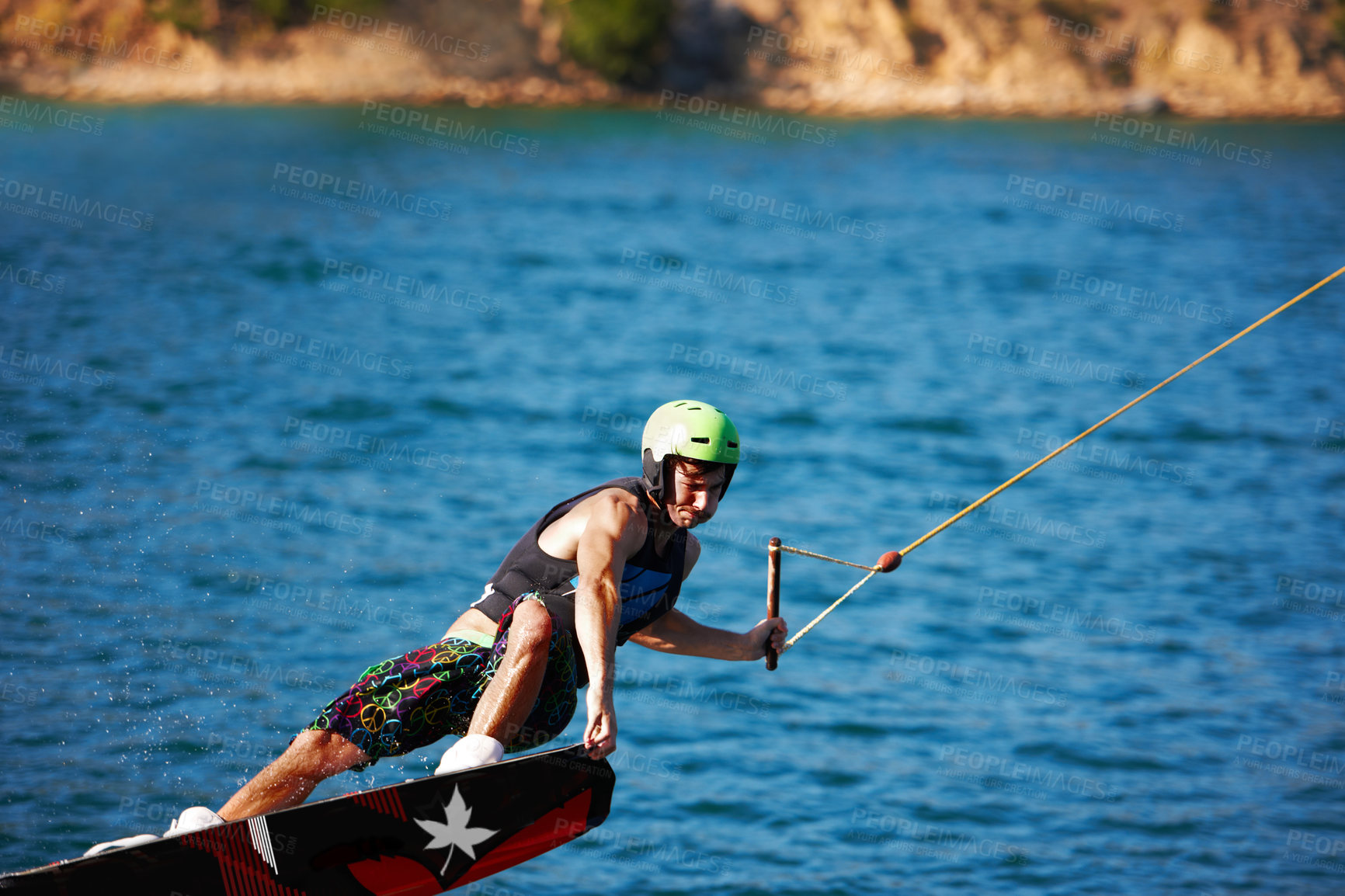 Buy stock photo Man, wakeboarding outdoor and lake with helmet, sport and fitness for speed in summer sunshine. Person, athlete and ski with rope for safety on water, sea or river for training, exercise and freedom