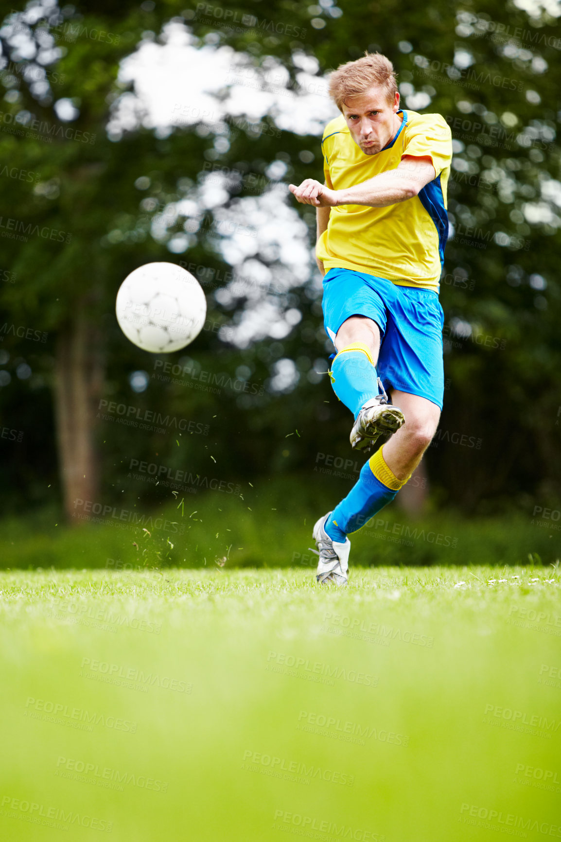 Buy stock photo Shot of a soccer player kicking the ball with gusto