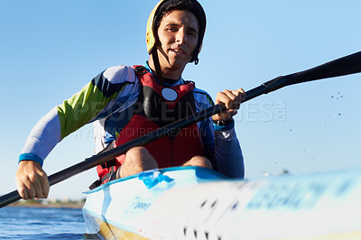 Buy stock photo Shot of a young man kayaking in a river