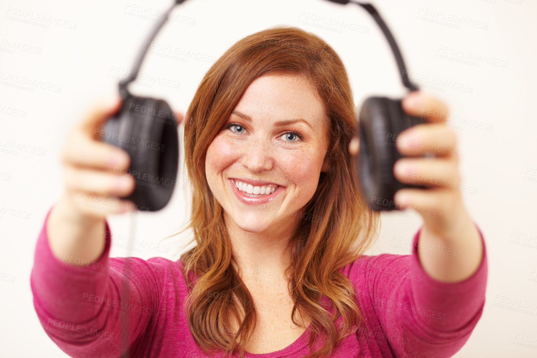 Buy stock photo Portrait of an attractive young woman offering you a pair of headphones 