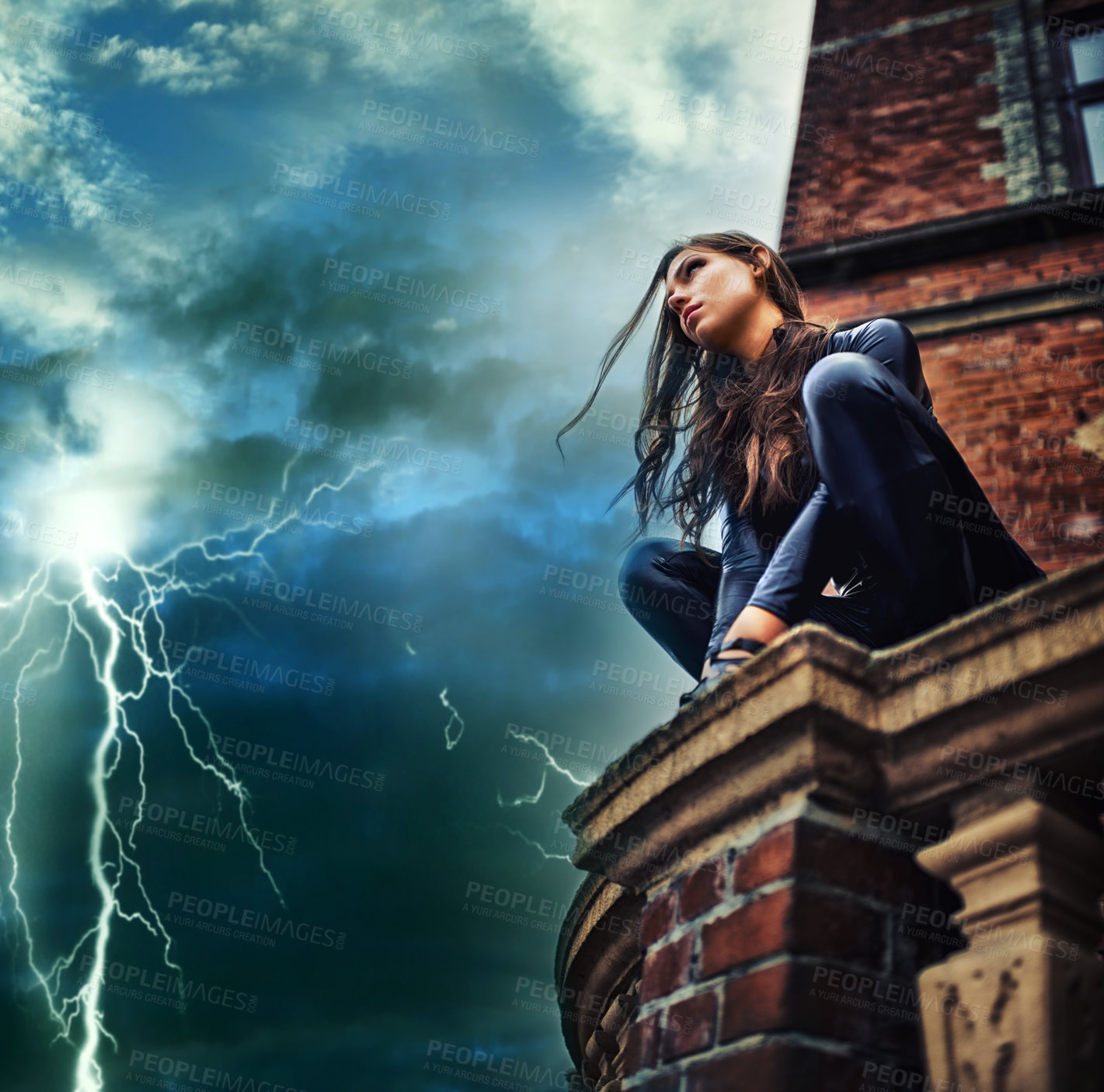 Buy stock photo Seductive young woman in a black catsuit crouched on a rooftop in a lightening storm