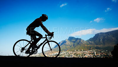 Buy stock photo Silhouette shot of a young woman cycling against a beautiful scenic view