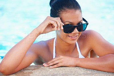 Buy stock photo Cropped view of a young woman in a swimming pool smiling while wearing shades